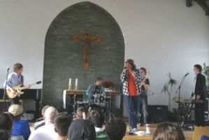 4 Musiker spielen in einer Kirche der Justizvollzugsanstalt vor Publikum